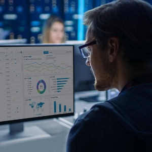 A man is looking at a computer screen with graphs on it.