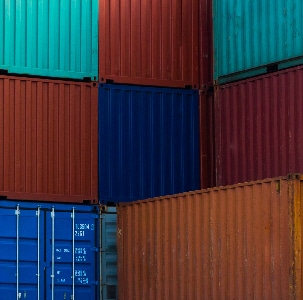 A stack of shipping containers undergoing customs inspection process.