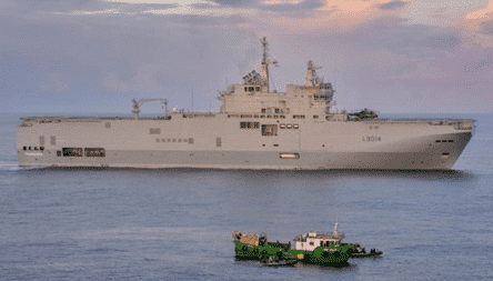 cocaine shipment. A large ship in the ocean with a small boat, linked to a recent EUR150 million cocaine seizure by Europol